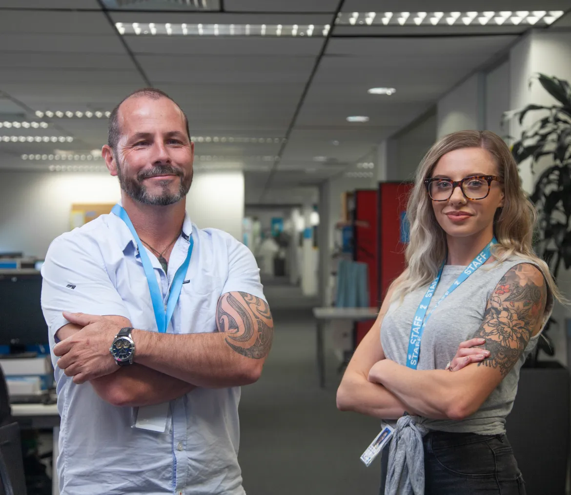 Two 2degrees employees wearing blue staff lanyards in an office